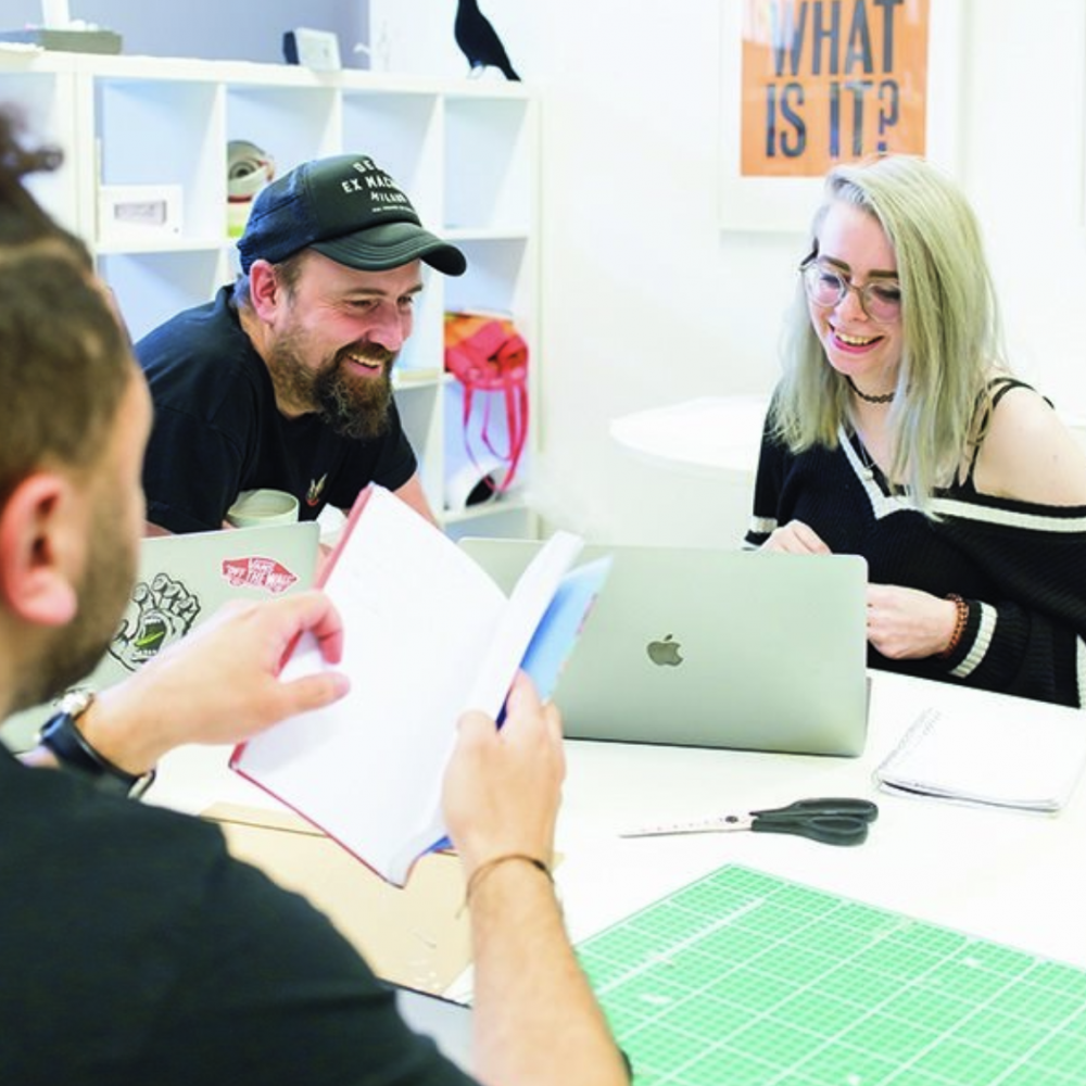Creative advertising students discussing work